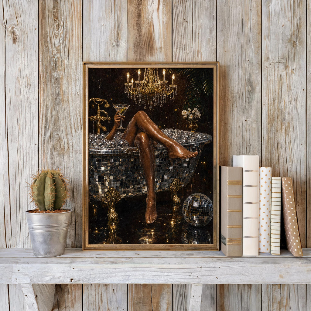 Framed black and gold disco ball bathtub art print on a rustic whitewashed shelf with a cactus and books, maximalist bathroom wall art
