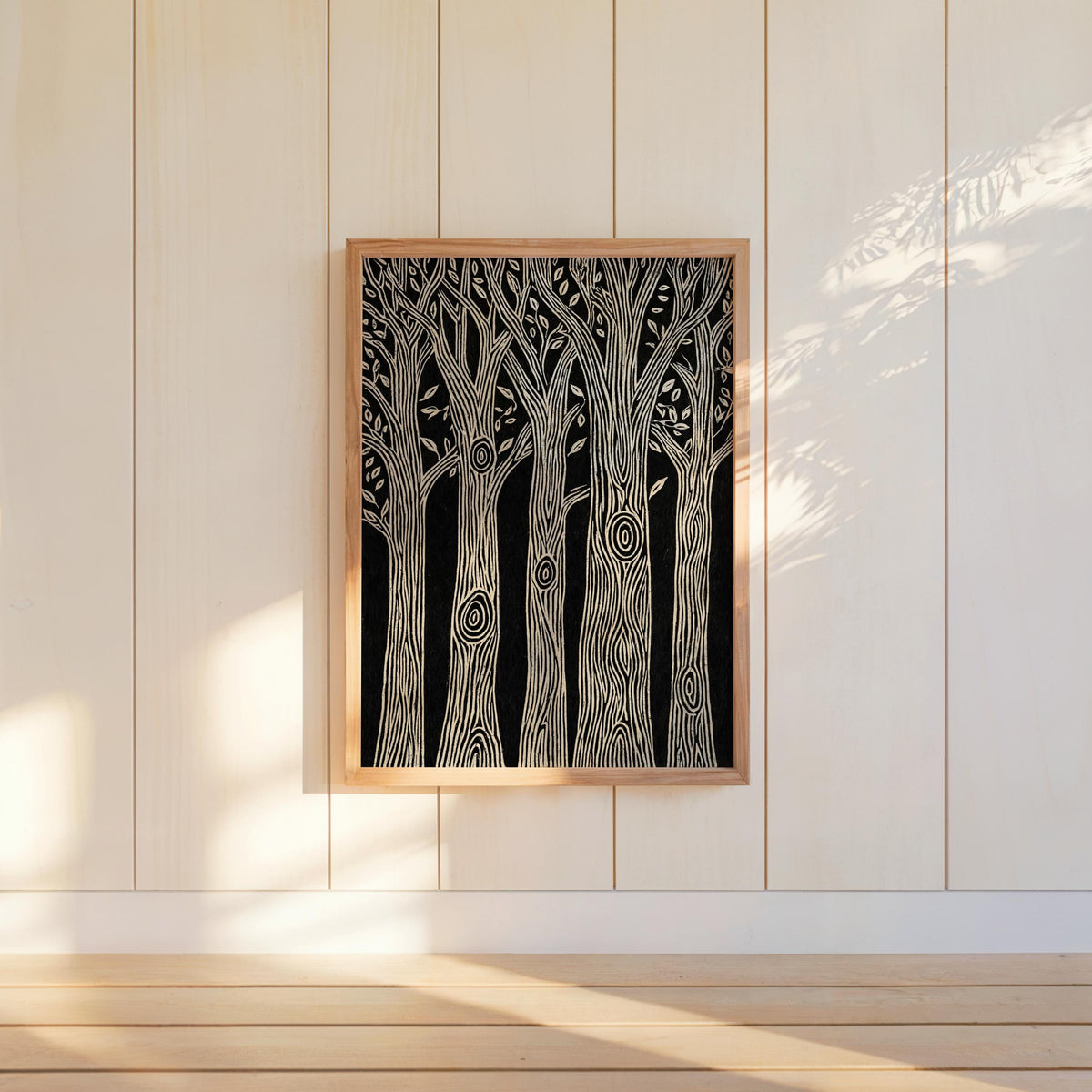 Framed black and white forest wall art centered on white paneled wall, soft window light, monochrome nature print appeal