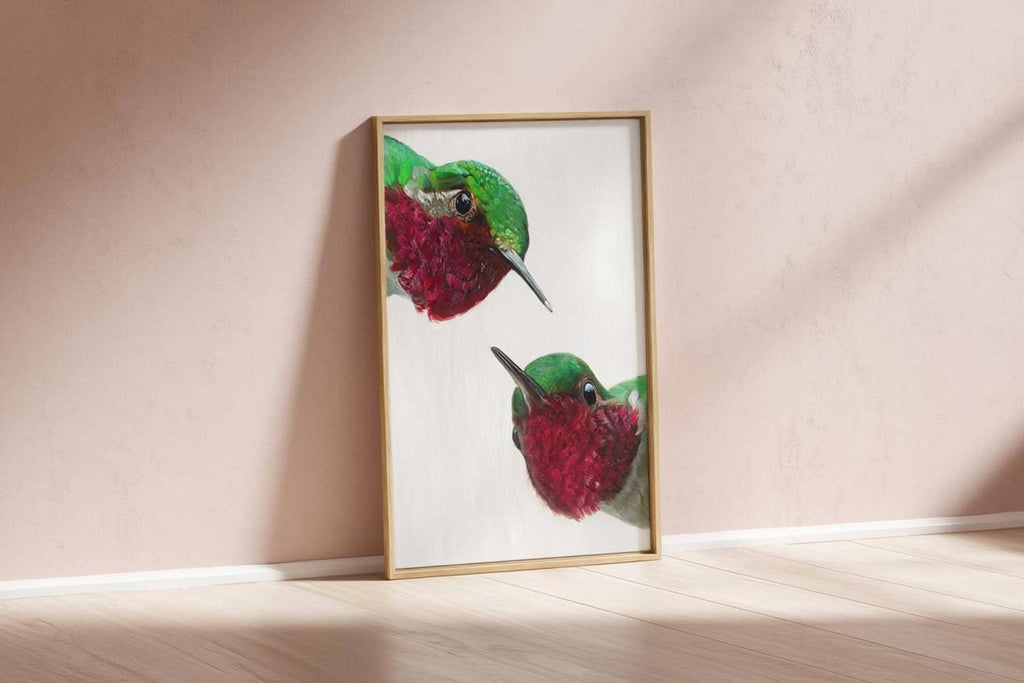Framed whimsical hummingbird wall art print propped against blush wall, modern mid century bird art vibe.