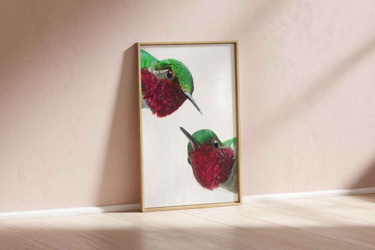 Framed whimsical hummingbird wall art print propped against blush wall, modern mid century bird art vibe.