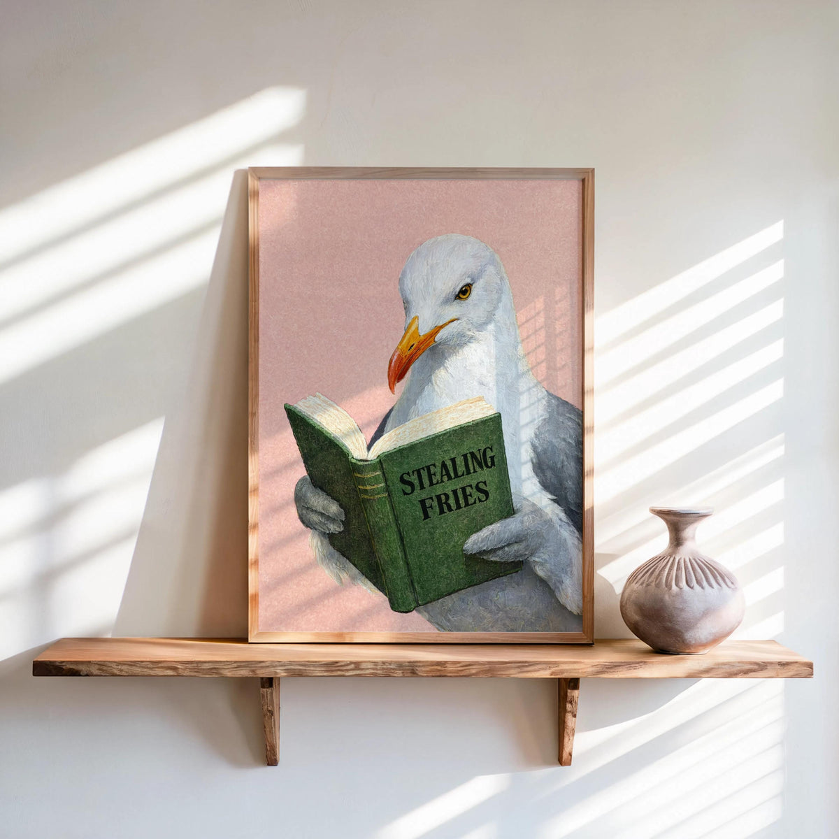 Soft pink backdrop, green book held by textured seagull, lean-on-shelf styling, funny seagull reading art print