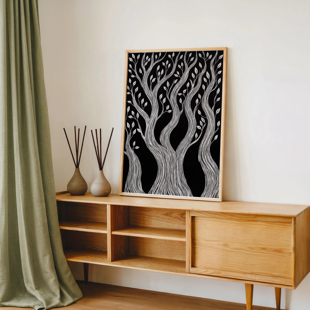 Natural wood console styling with framed black background tree art, botanical block print beside vases and curtain