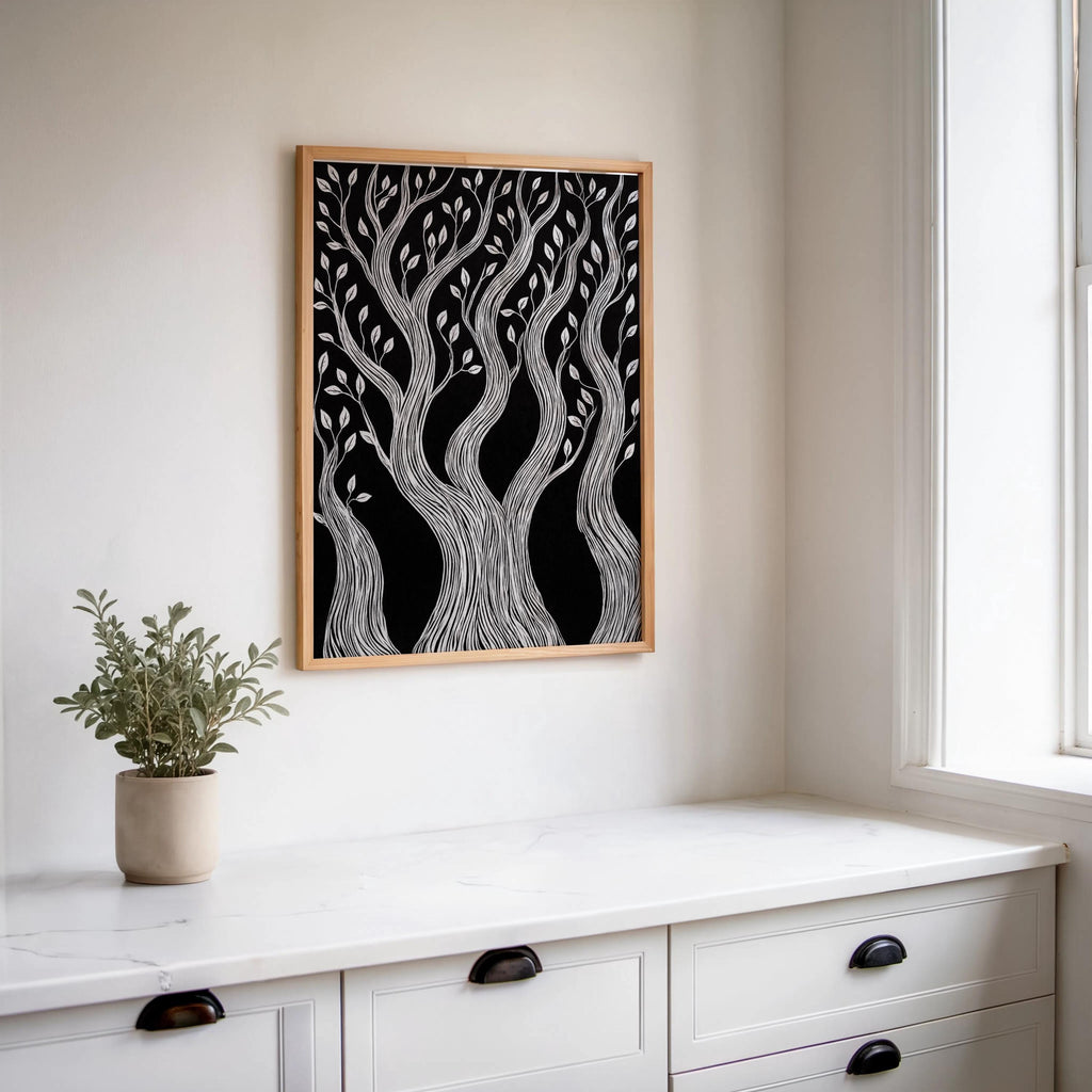 Framed botanical block print centered above white console, black and white forest wall art with small potted plant