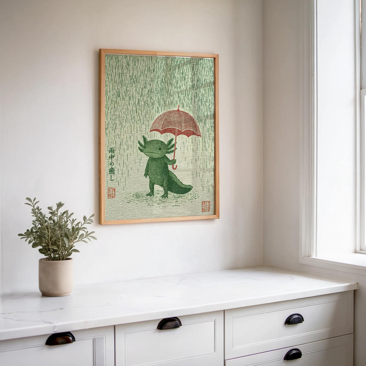 Hanging Axolotl Wall Art Print above a kitchen counter, potted plant beside it, rainy day wall art charm