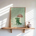 Leaning Axolotl Wall Art Print on a sunlit wooden shelf, green axolotl under red umbrella, textured rain