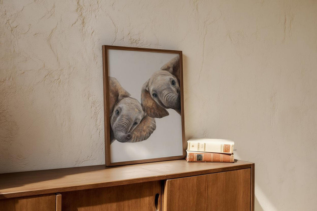 Wood console with leaned safari nursery wall art, elephant nursery decor beside small stack of books