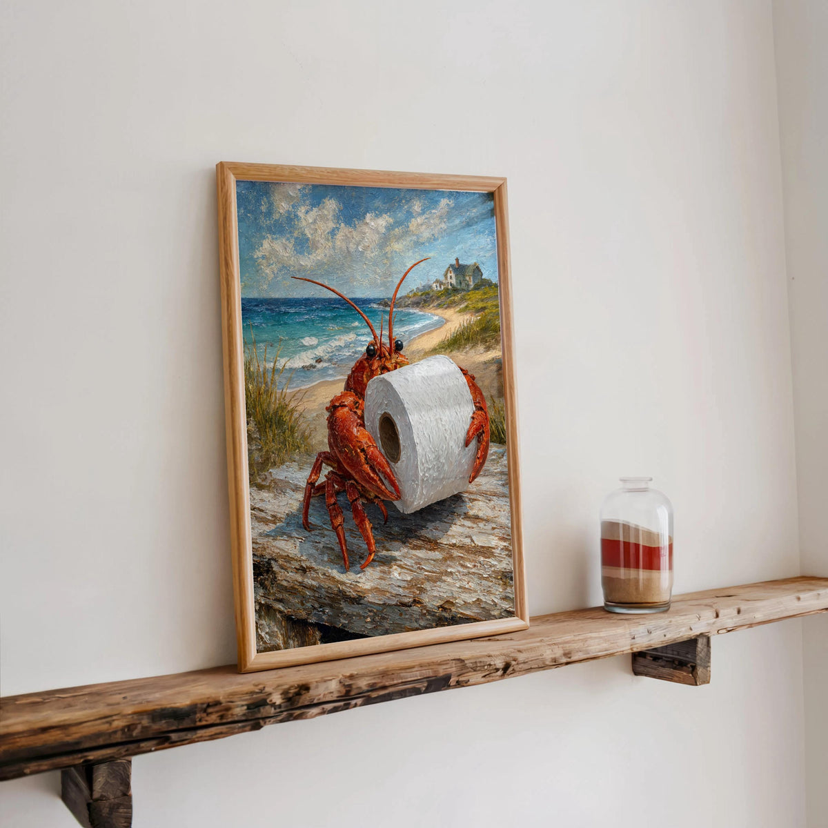 Narrow reclaimed wood shelf holding framed funny lobster bathroom print and a small jar candle, coastal bathroom wall art staging