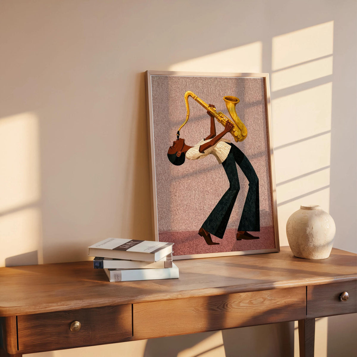 Afrocentric jazz wall art print on desk with warm light, blush pink canvas, stylized black musician silhouette.