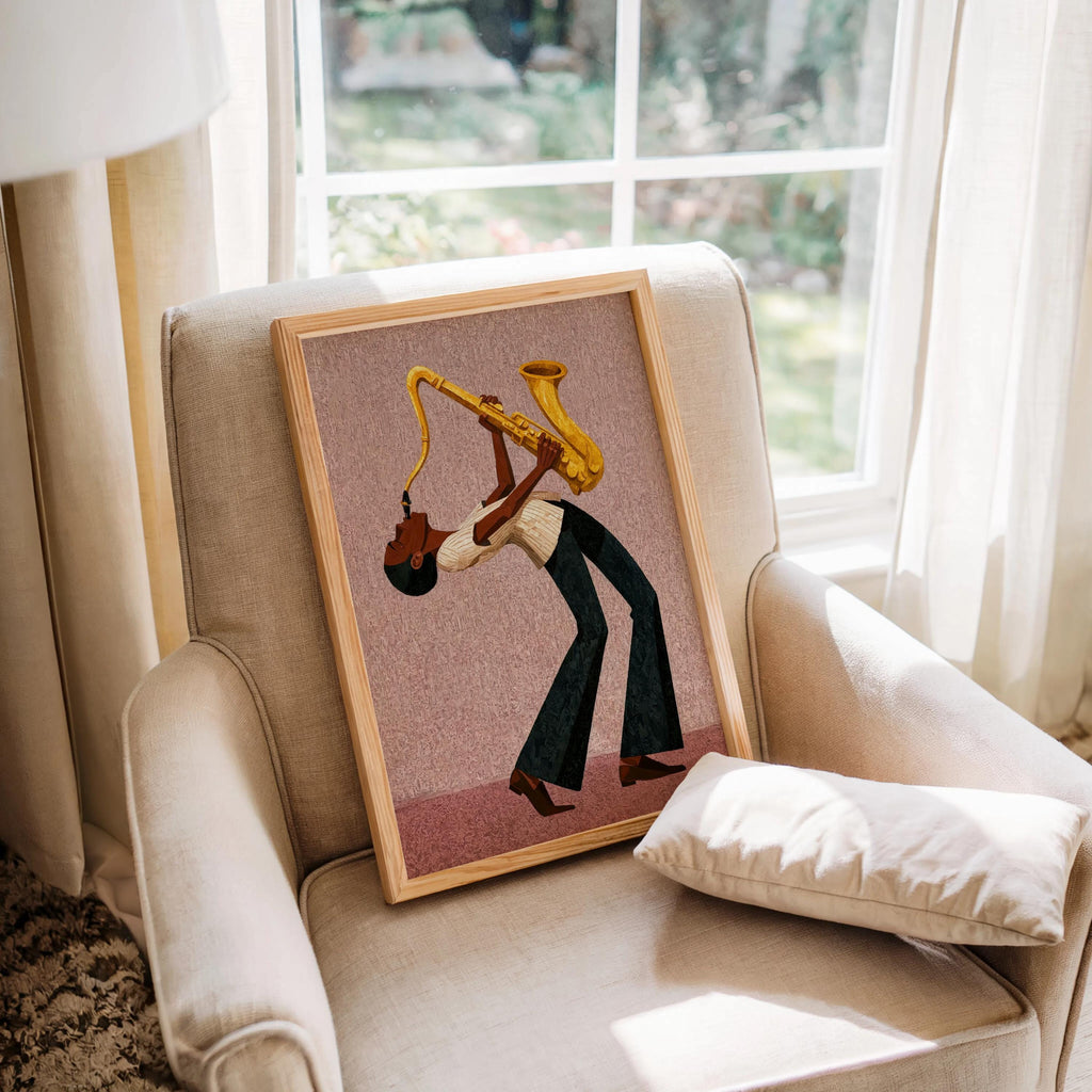 Afrocentric jazz wall art print displayed on armchair by window, blush pink background, warm sunlight.