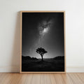 Framed black and white joshua tree night sky wall art leaning against white wall, maple hardwood floor