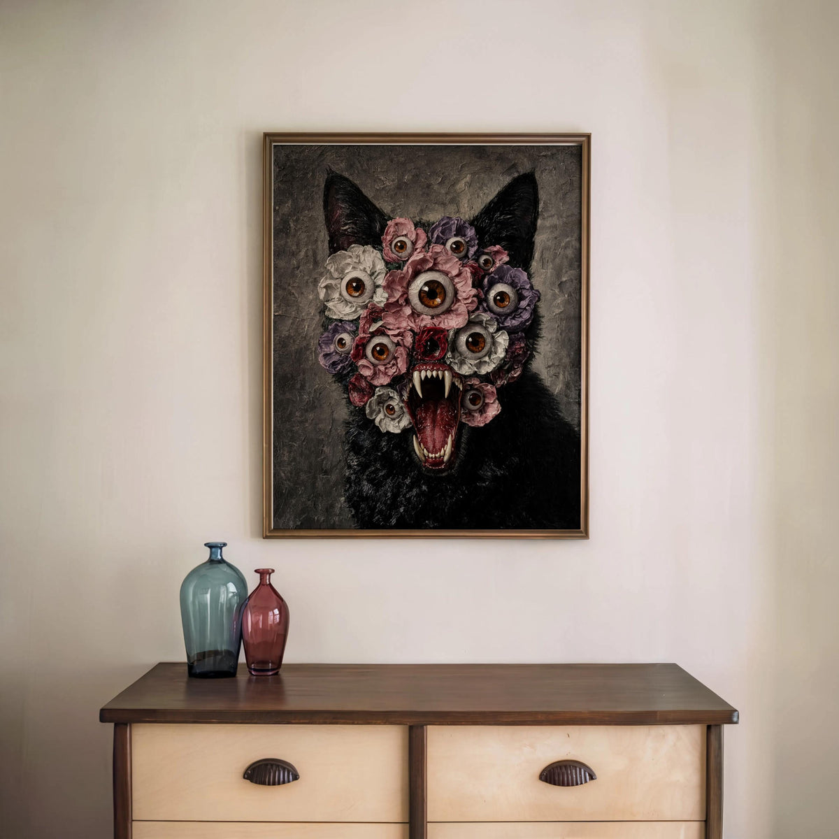 Weirdcore art print centered above a small sideboard with two glass vases, the black cat floral wall art framed plainly