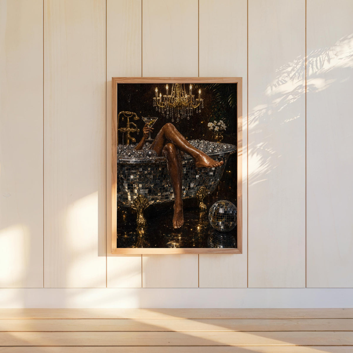 Black and gold wall art, disco ball bathtub art print hung on bright shiplap, sunlight accentuating glittering disco details
