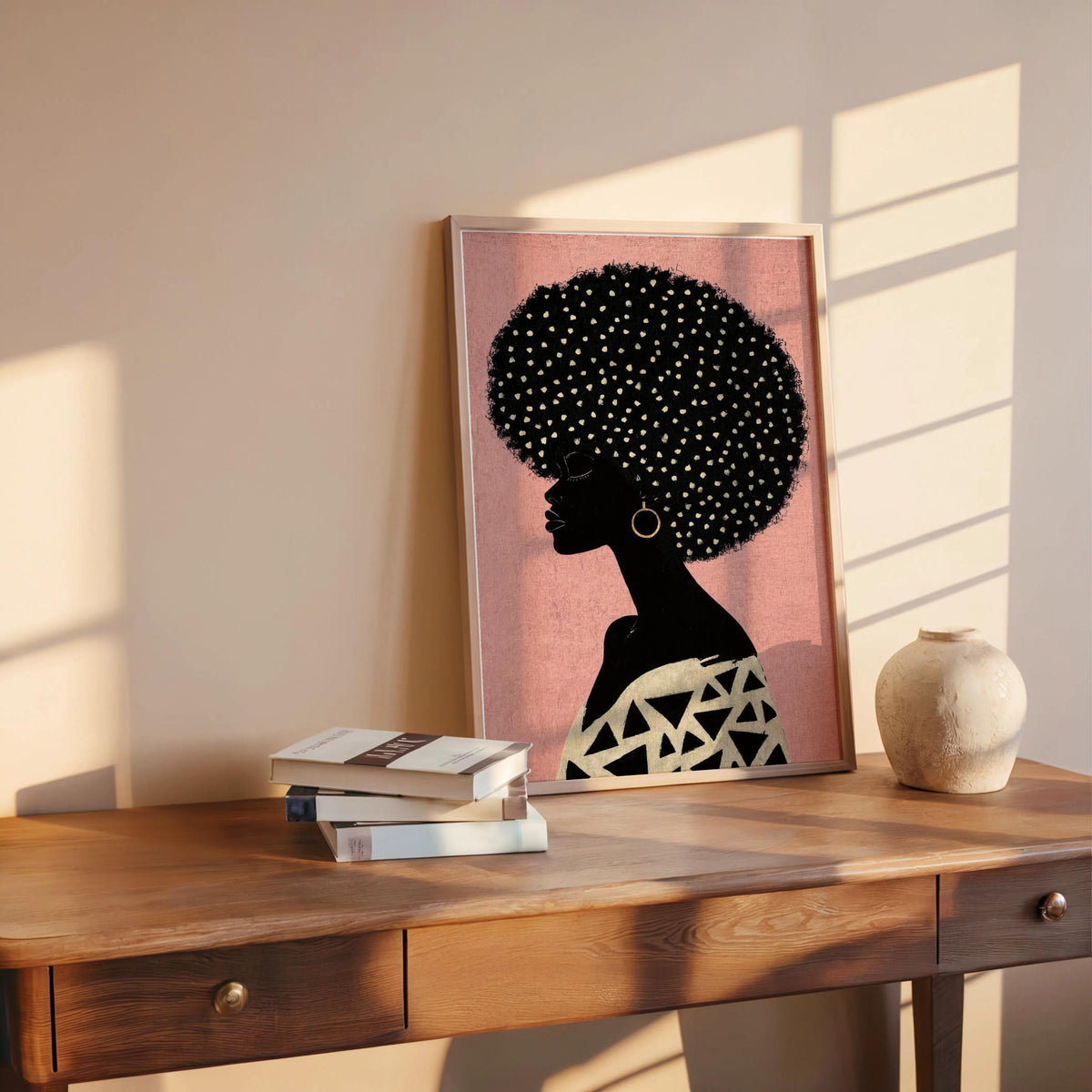 Blush pink print on a warm wood desk, feminine Black woman silhouette with white and gold dotted afro, Afrocentric Black woman wall art