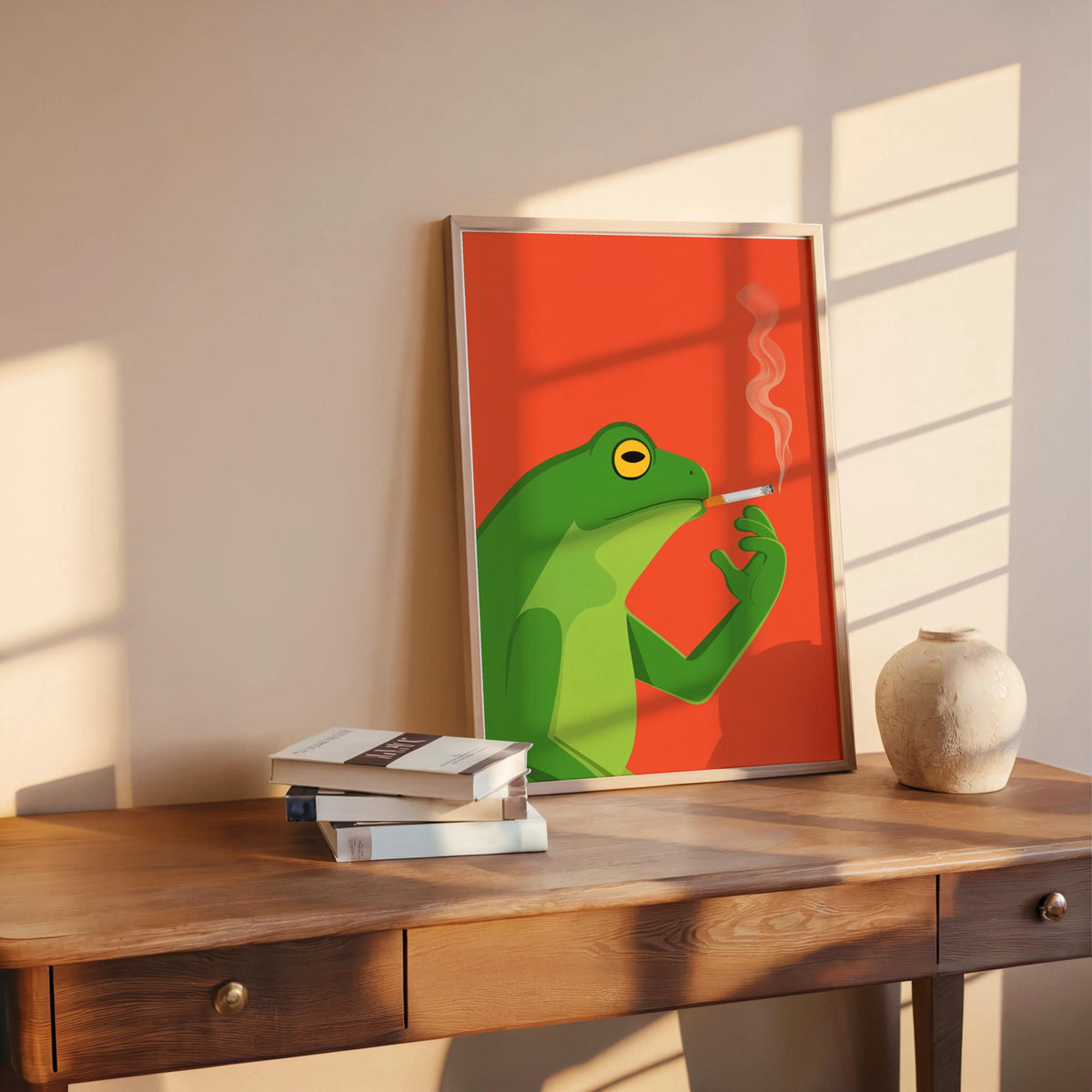 Funny frog wall art print resting on rustic desk in warm sunlight, vintage style frog artwork