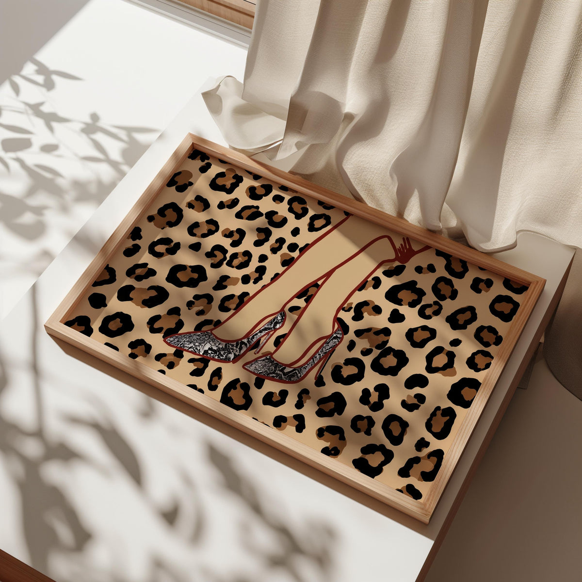 Angled close-up of framed leopard print high heel wall art in box, shows frame edge and snake print shoe art