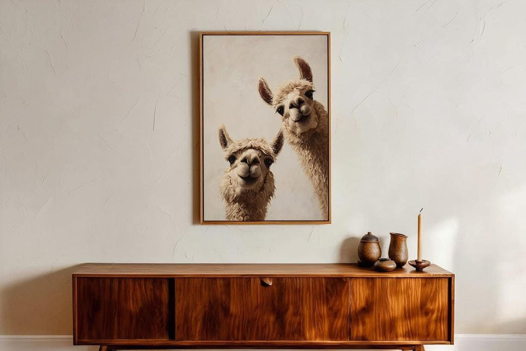 Framed llama duo hung above a mid century wooden credenza, warm neutrals, funny animal wall art print offered as a digital download
