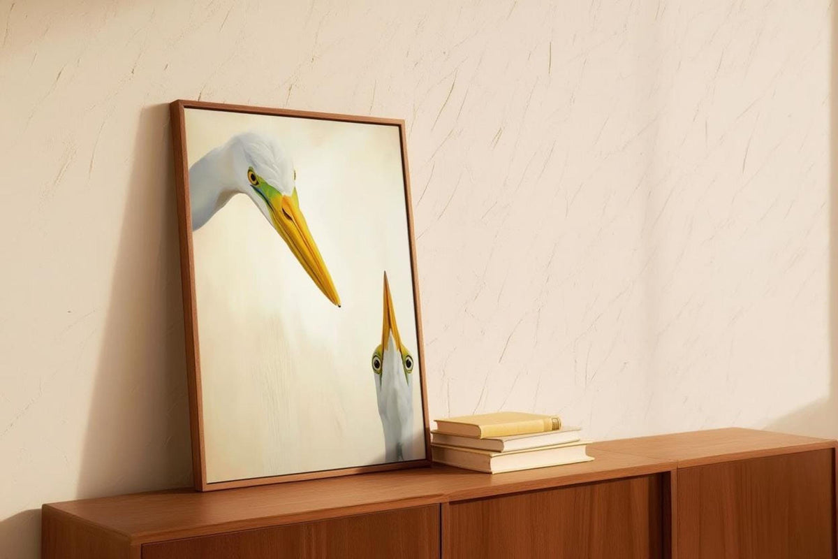 Wood console with leaning framed egret print, warm light and stacked books, mid century modern bird print