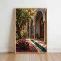 Framed Persian courtyard wall art leaning on a white wall, sunlit arches, pomegranate tree, blue-green tiled pool