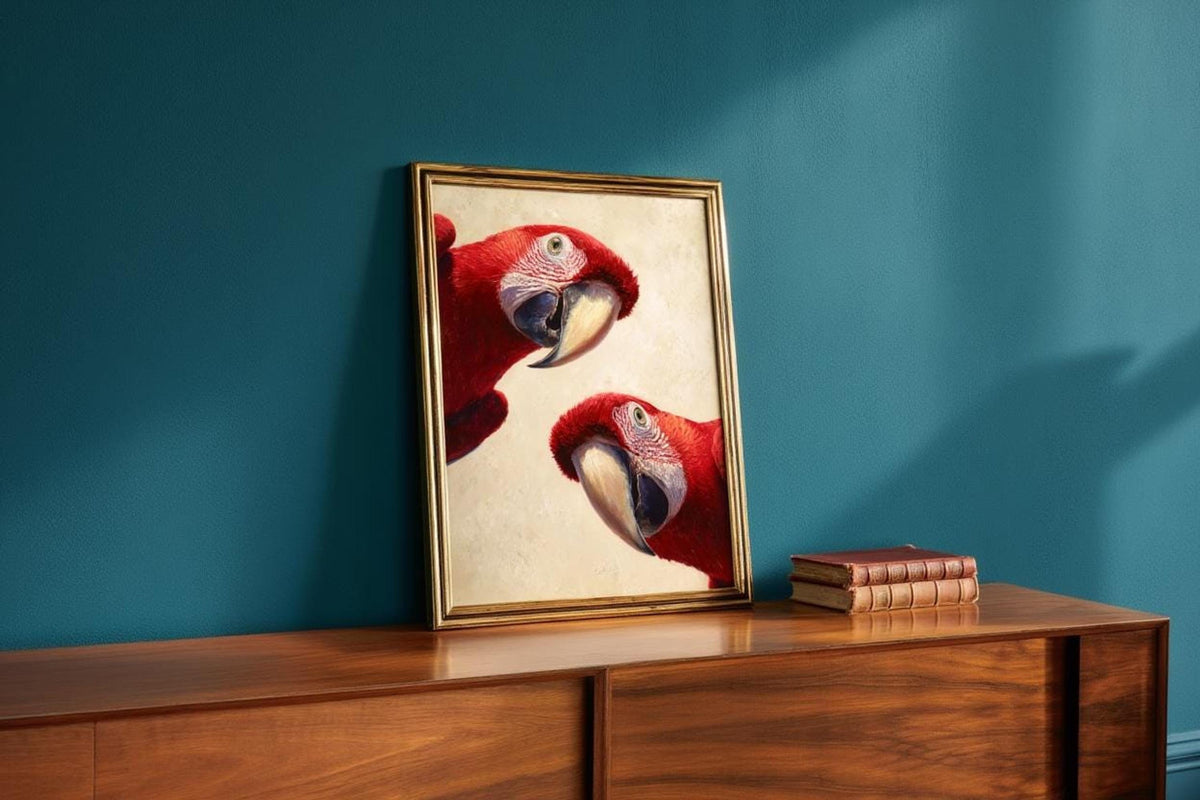 Tropical nursery wall art styled against a teal wall, framed macaw poster propped with stacked books and warm light