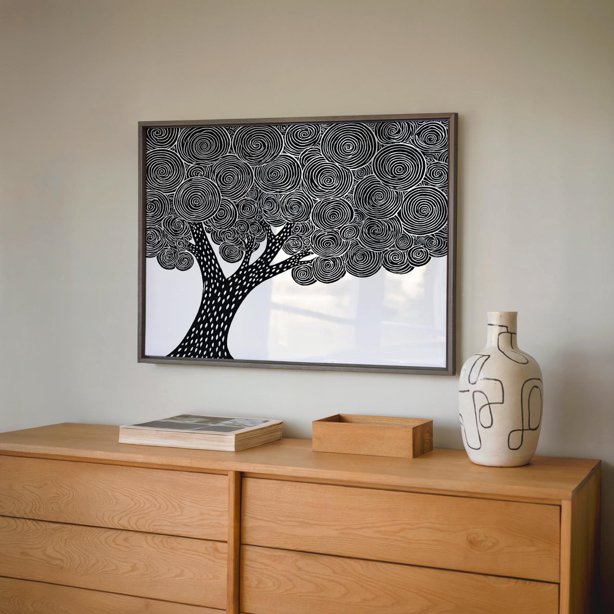 Framed black and white tree wall art above a dresser with pottery, abstract tree wall art, botanical vibe