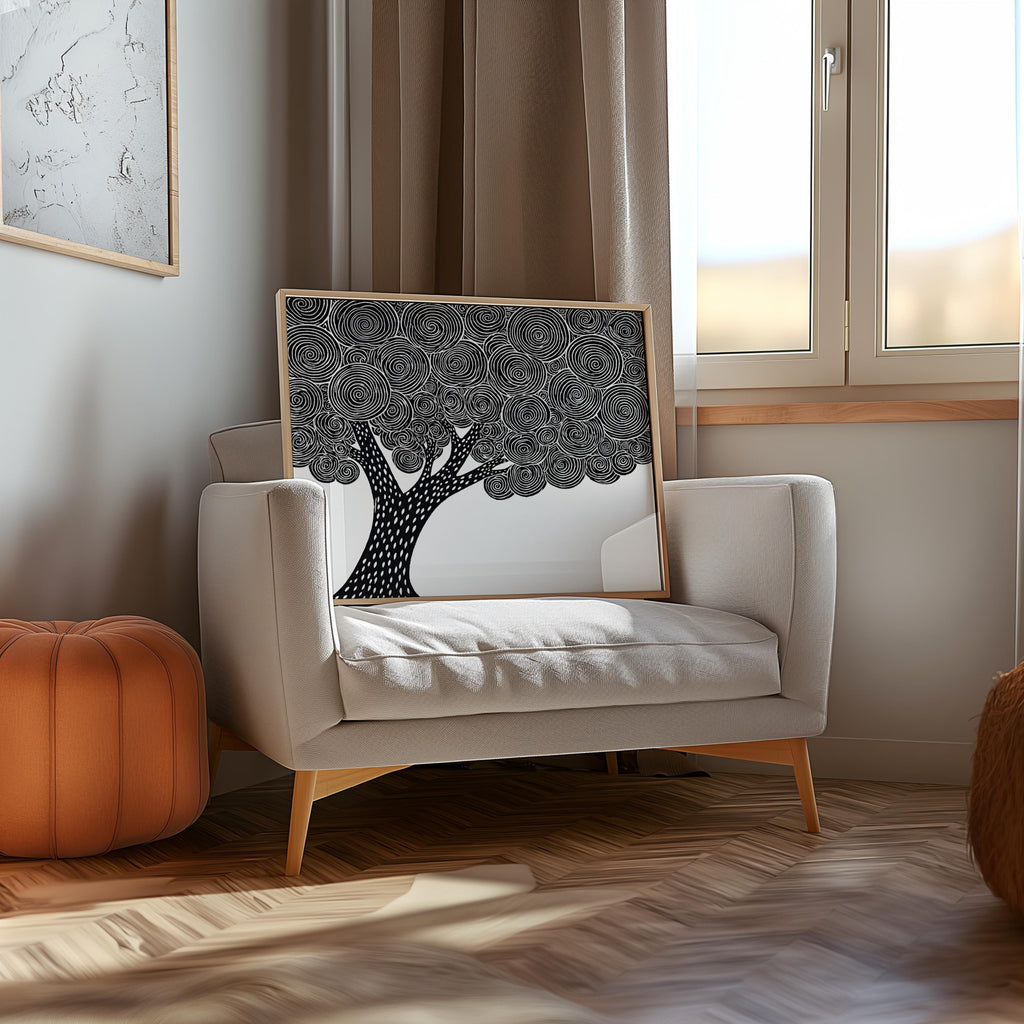 Black and white tree wall art propped on a cozy armchair by a window, woodblock tree print texture