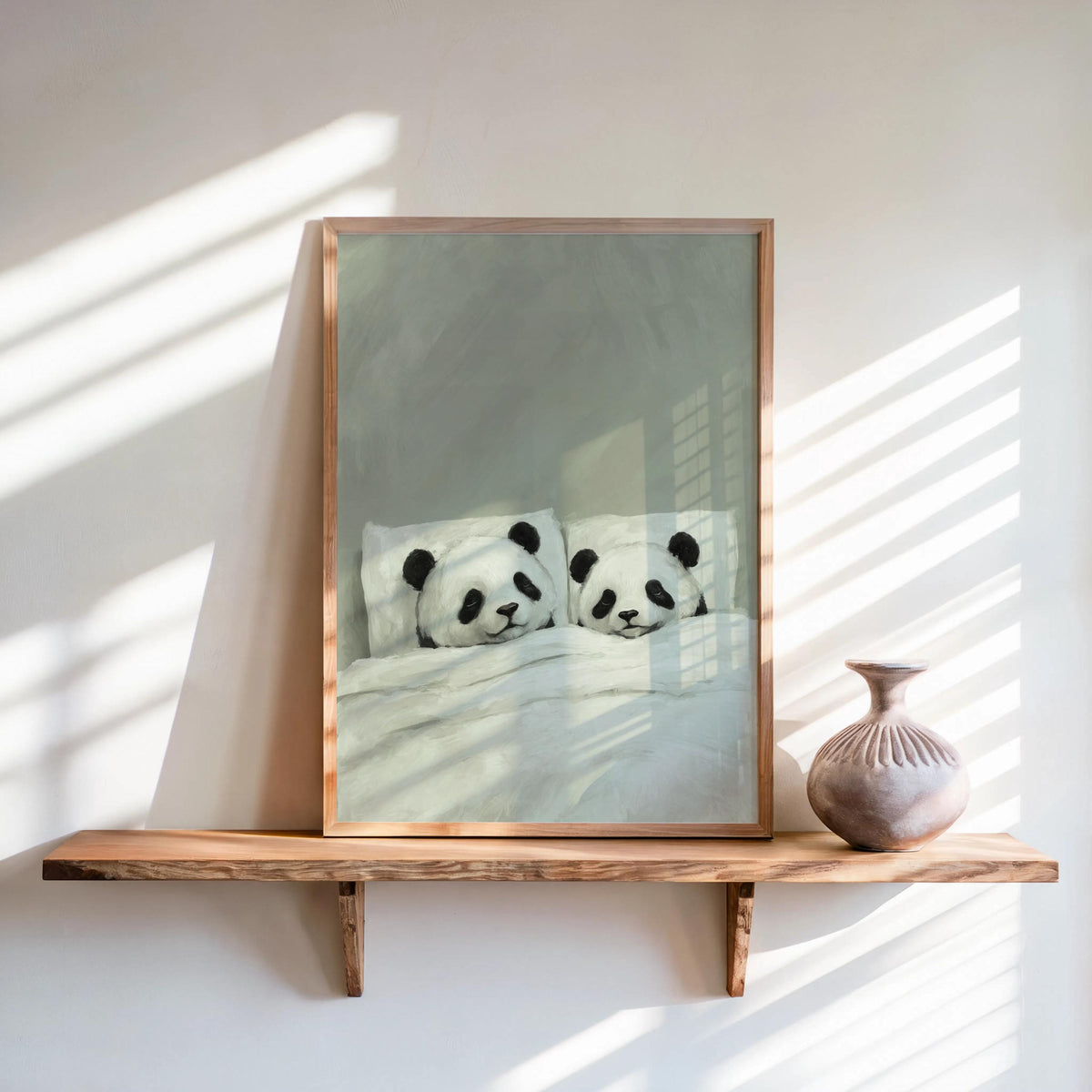 Sage green sleeping panda wall art in a slim frame on a shelf, warm window light, panda couple print for nursery