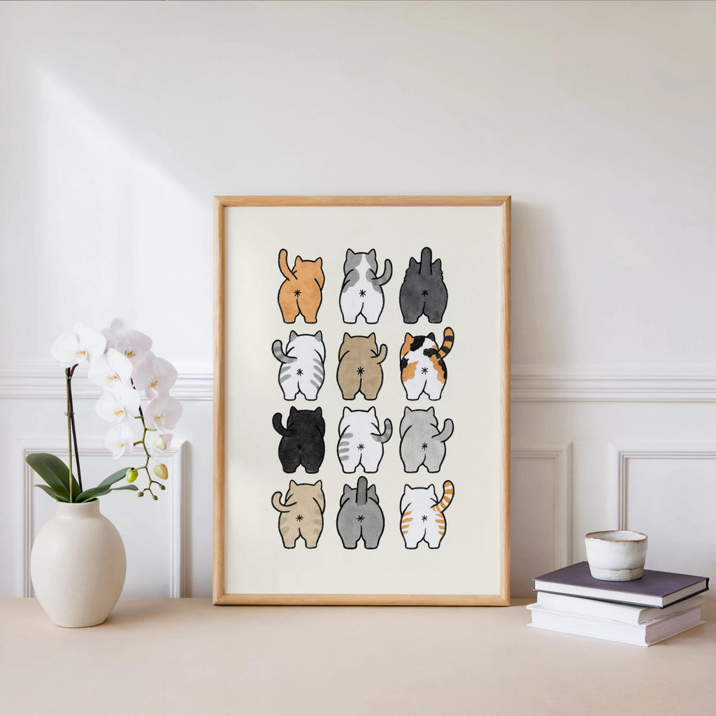 Print leaning against a white wall with potted orchid, soft watercolor cat rears in warm tones, cute cat watercolor print