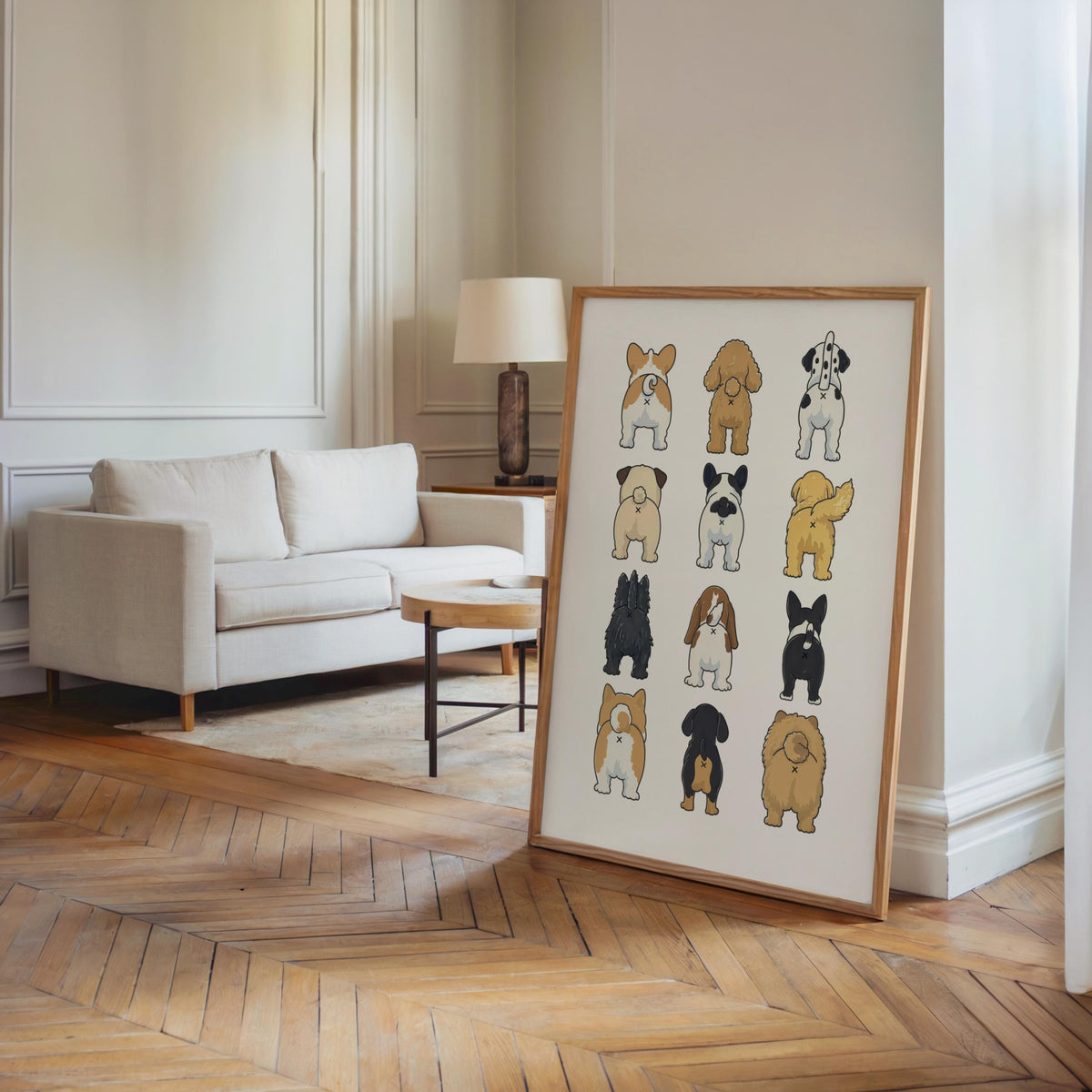 Tall framed funny dog butt bathroom art print leaned by a sofa in a bright living room, neutral tones