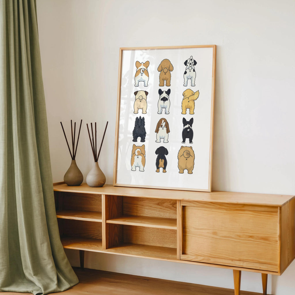 Funny dog butt bathroom art print on midcentury console, styled with vases, books, and a green drape