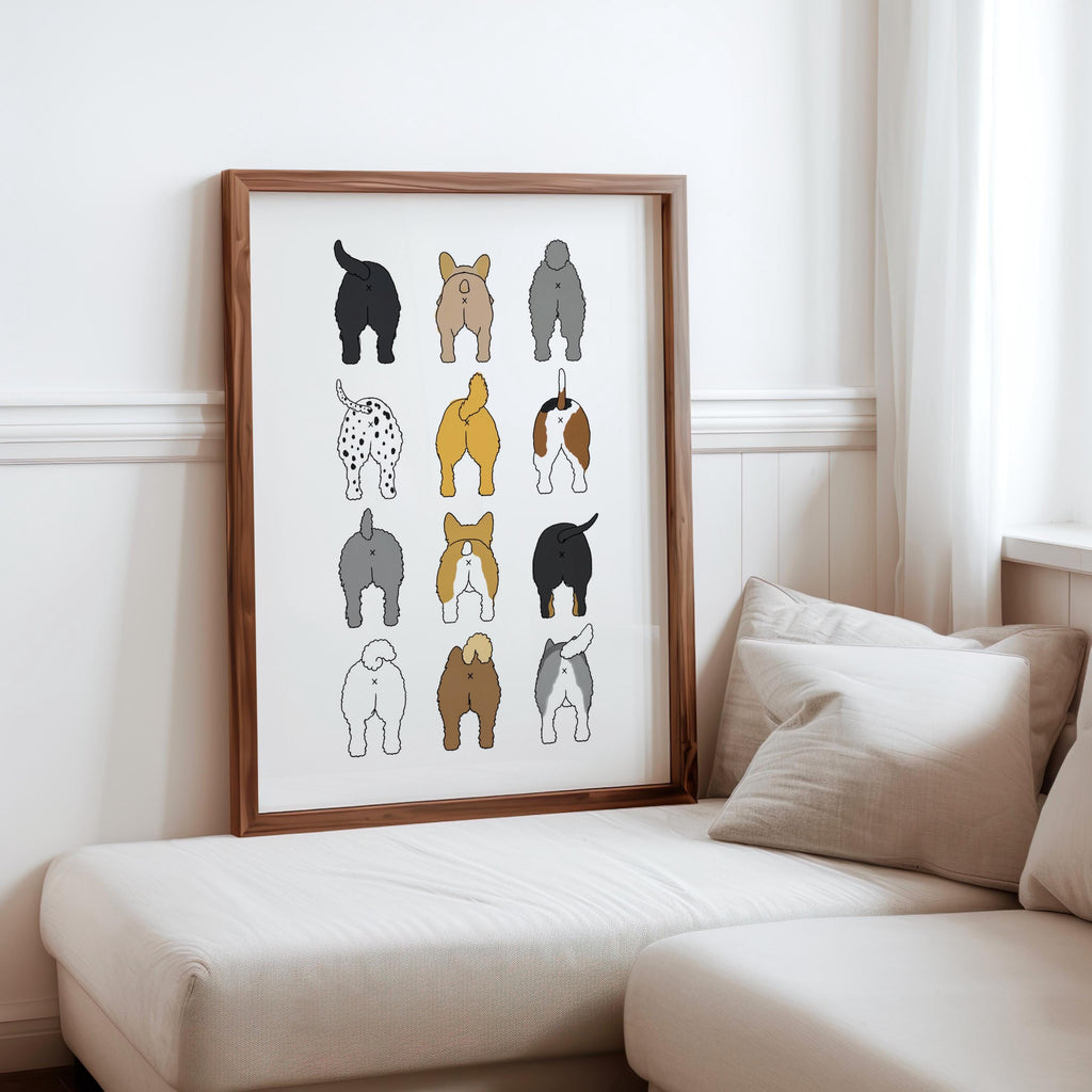 Framed 3-by-4 dog butt grid leaning beside a sofa and cushions, soft curtain light, funny dog bathroom art styling