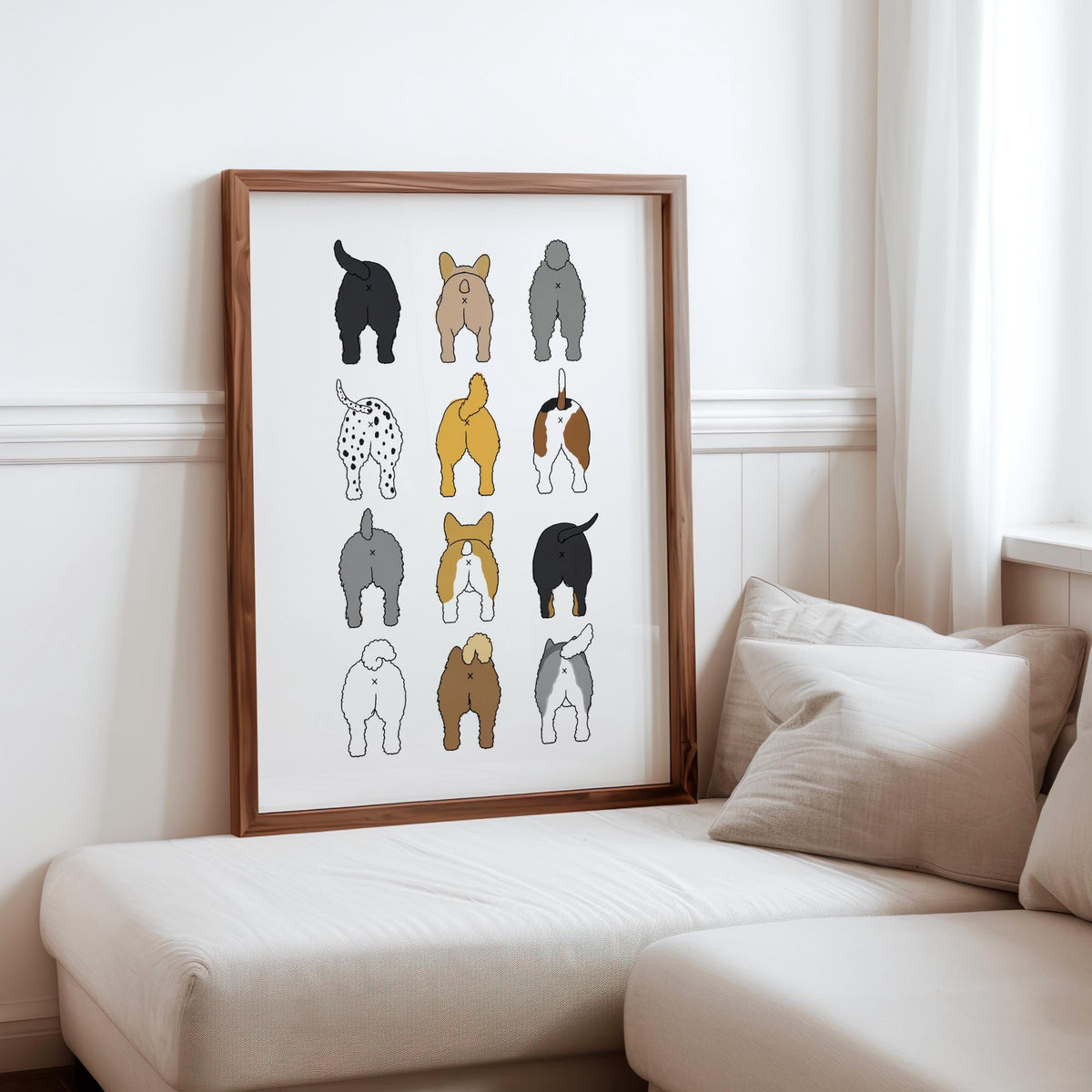 Framed 3-by-4 dog butt grid leaning beside a sofa and cushions, soft curtain light, funny dog bathroom art styling