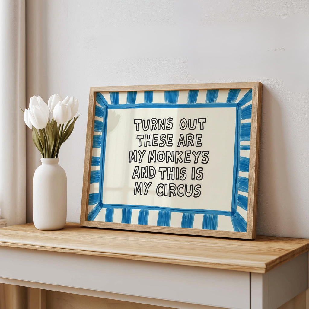 Blue striped framed print leaned on console near curtain, colorful typography wall art, office humor wall art, funny quote wall art.