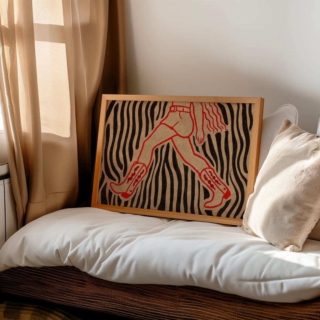 Zebra cowgirl wall art print leaning on bed, western bedroom decor styling with pillows and warm neutral tones