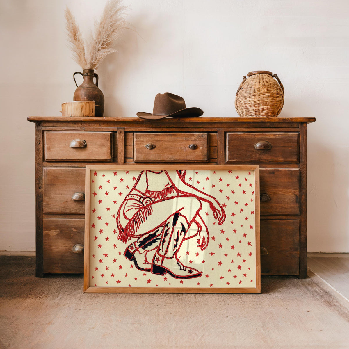 Rustic dresser background, western cowgirl wall art in deep red on cream, scattered star pattern beside decor items