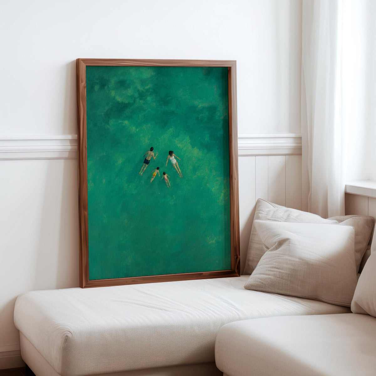 Family swimming wall art in a warm wood frame beside a cozy beige sofa, emerald-green water scene