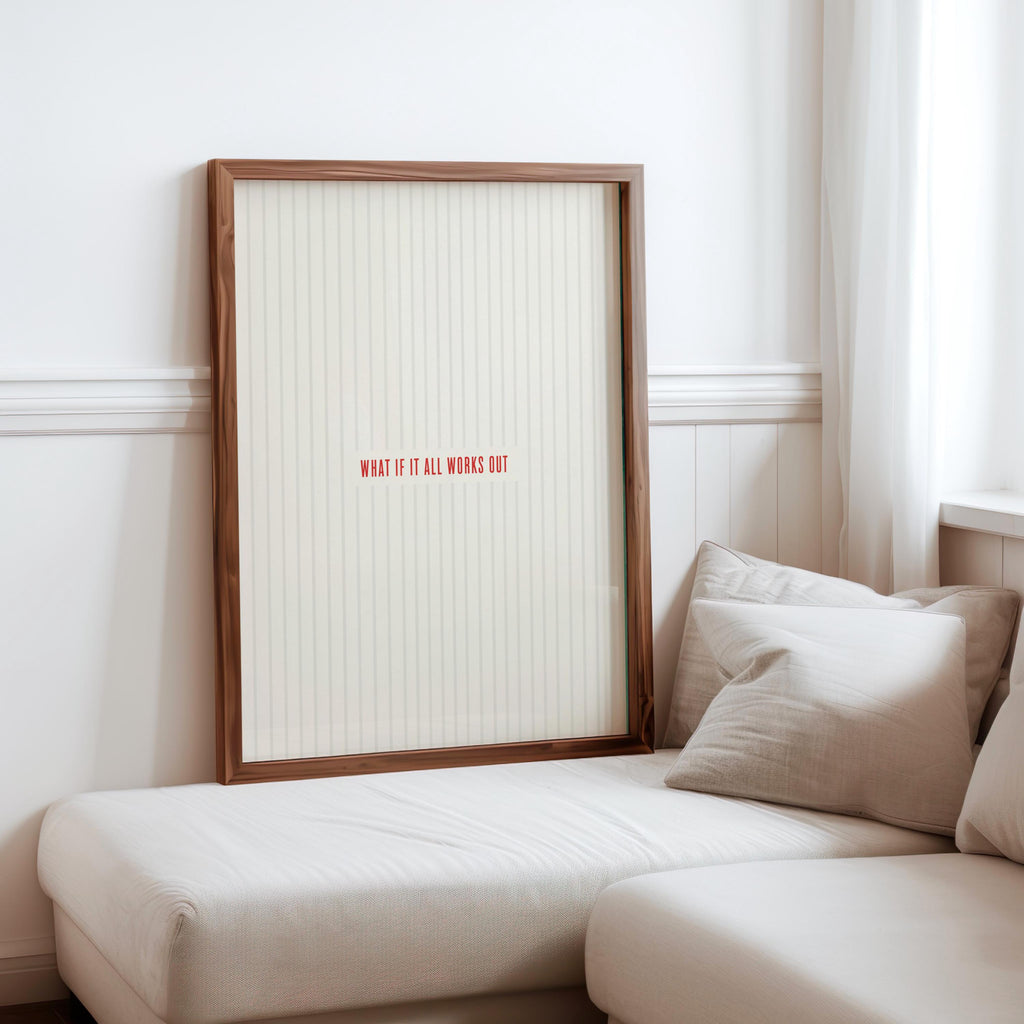 What if it all works out art leaning on a sofa corner, light wood frame, cozy neutral styling