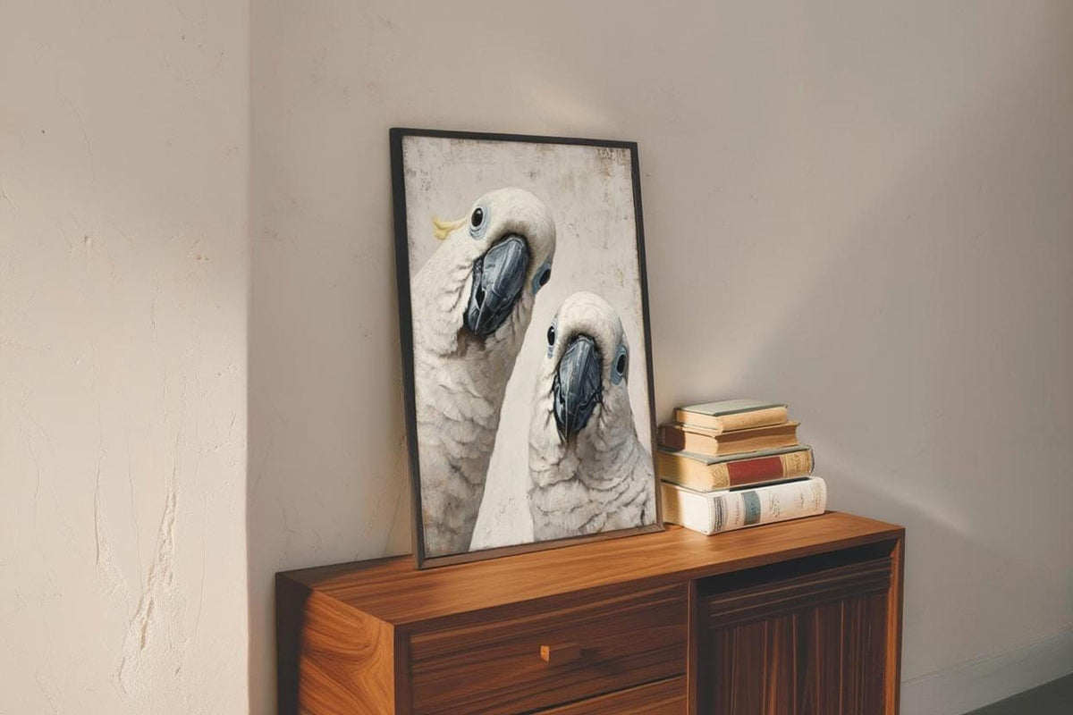 Funny cockatoo wall art print propped on a midcentury dresser, white cockatoos peering with slate grey beaks