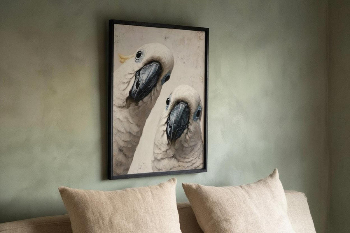 Framed funny cockatoo wall art print hung above a sofa, soft grey feathers and playful close-up composition