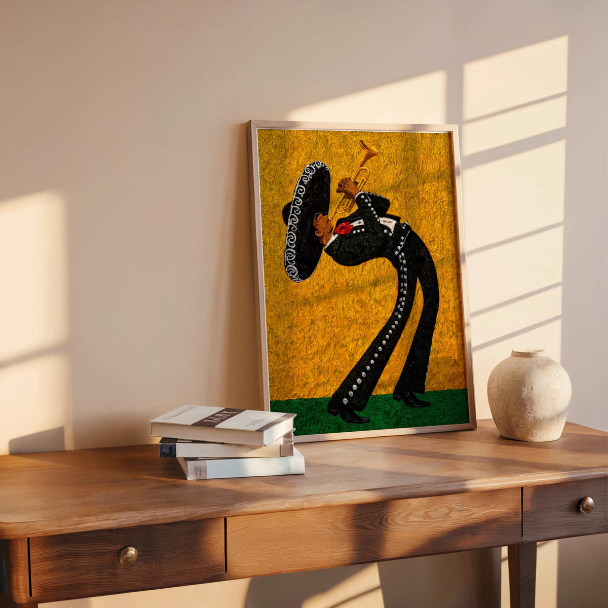 Gold yellow mariachi wall art print leaning on wooden shelf, small book stack and round vase, colorful Mexican decor accent