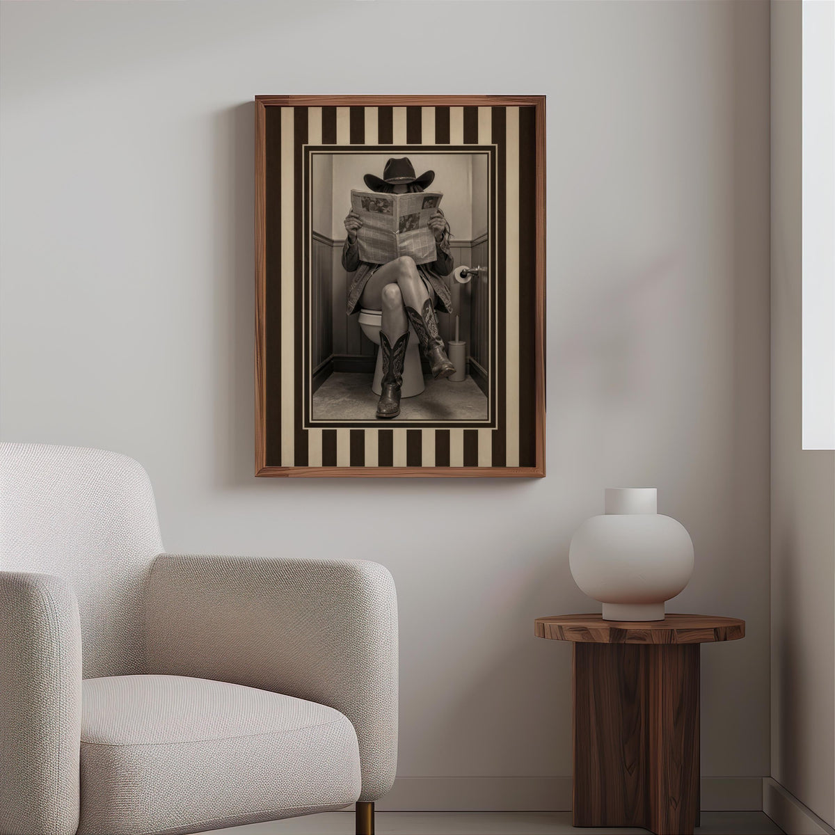 Small framed vintage cowgirl print hung above a modern side table and boucle chair, quirky powder room decor, funny cowgirl bathroom wall art