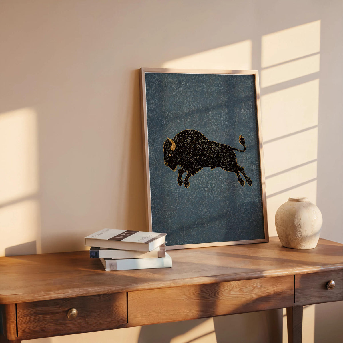 Bison wall art print leaning on desk, slate blue background, black bison illustration, cozy light