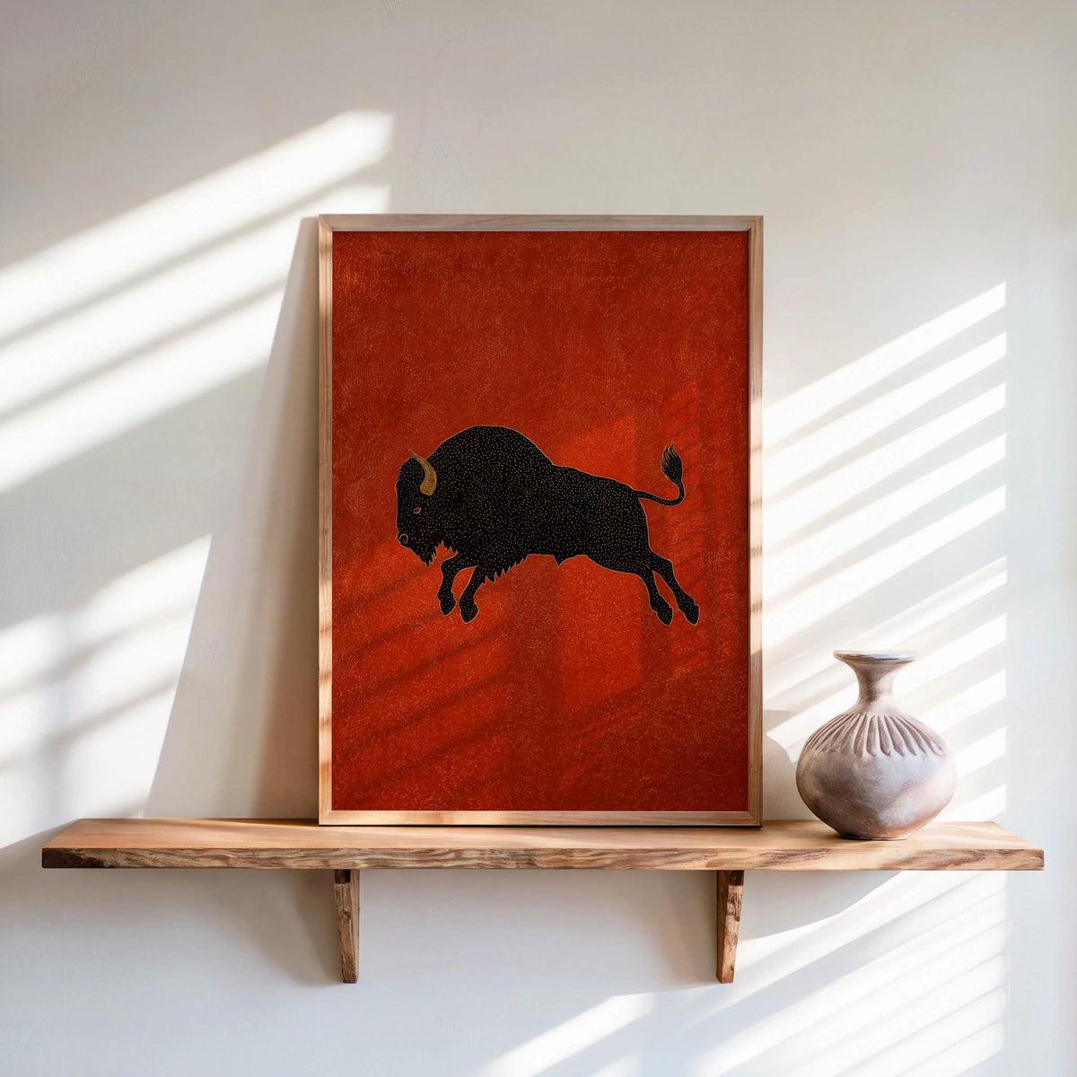 Bison wall art print, black bison illustration on earthy red background, framed on sunlit shelf