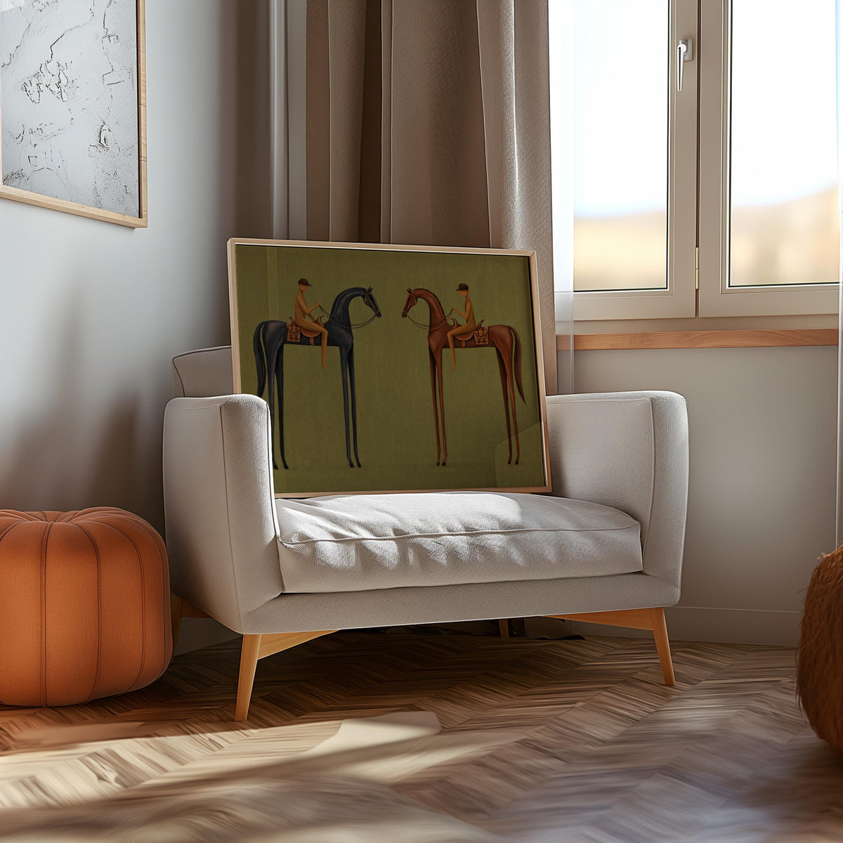 Framed print leaning by gray armchair, minimalist equestrian wall art in a cozy neutral living room setting