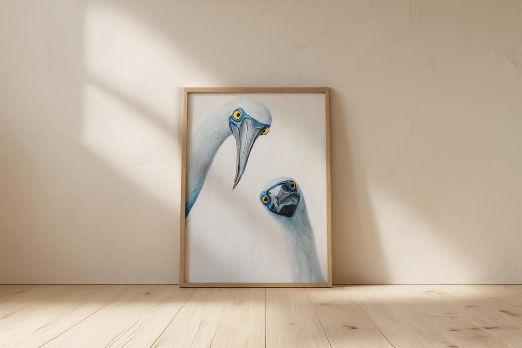Framed print resting on floor against bright wall with long shadows, mid century modern animal art accent, blue footed booby wall art print