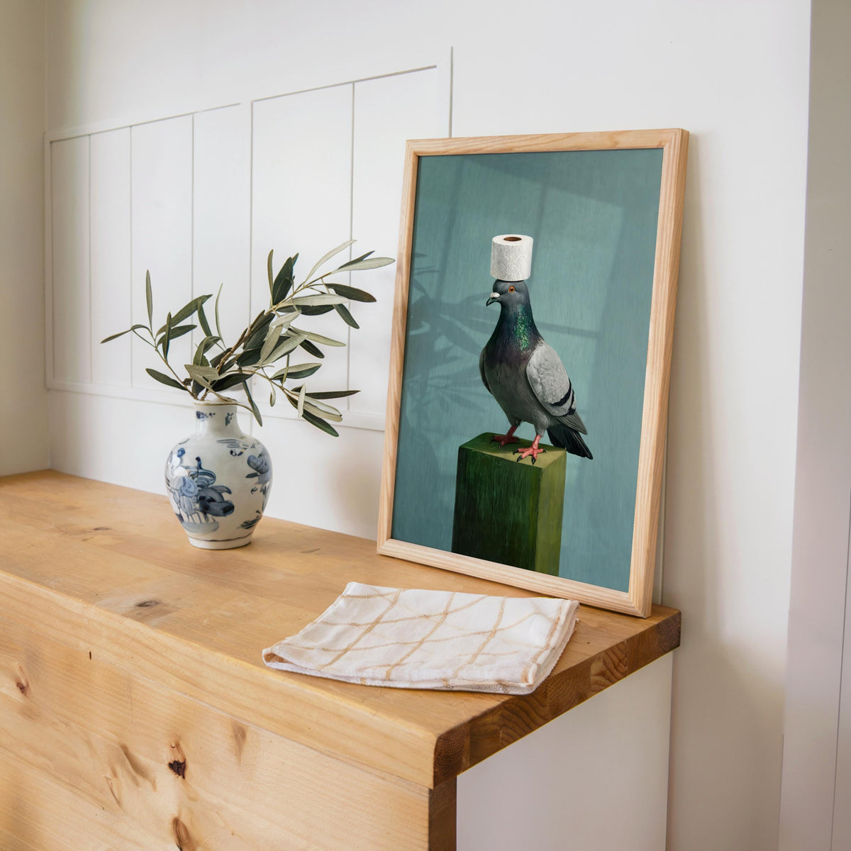 Funny pigeon wall art propped on wooden console with plant and vase, pigeon art print, frame not included