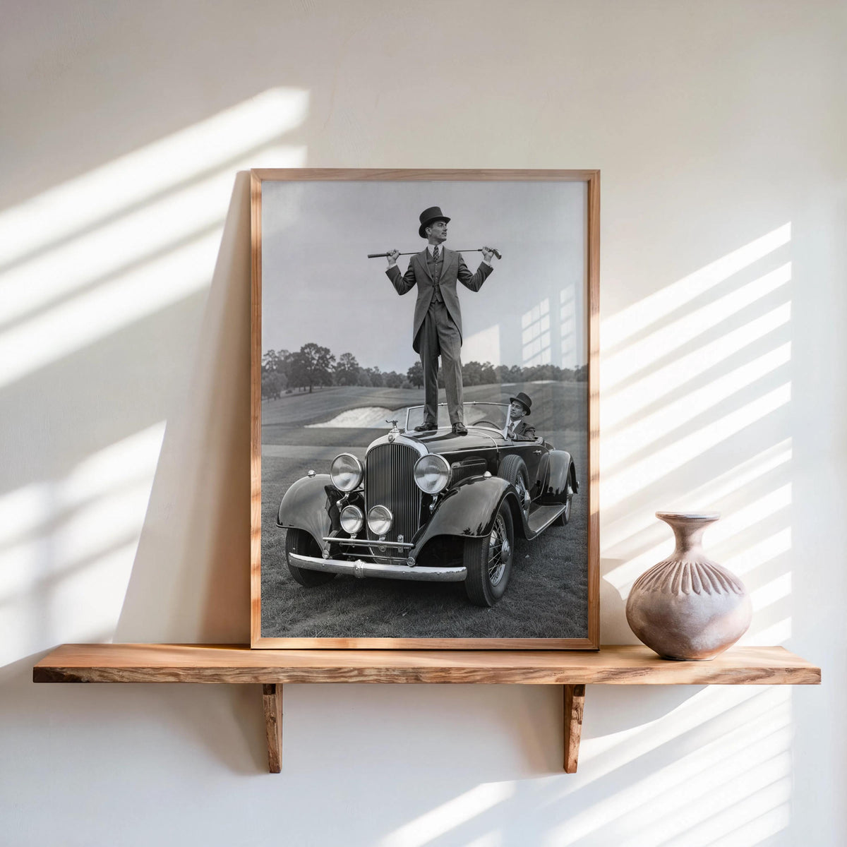 Print displayed on a floating shelf with soft shadows, dapper gentleman on hood, vintage golf poster tone