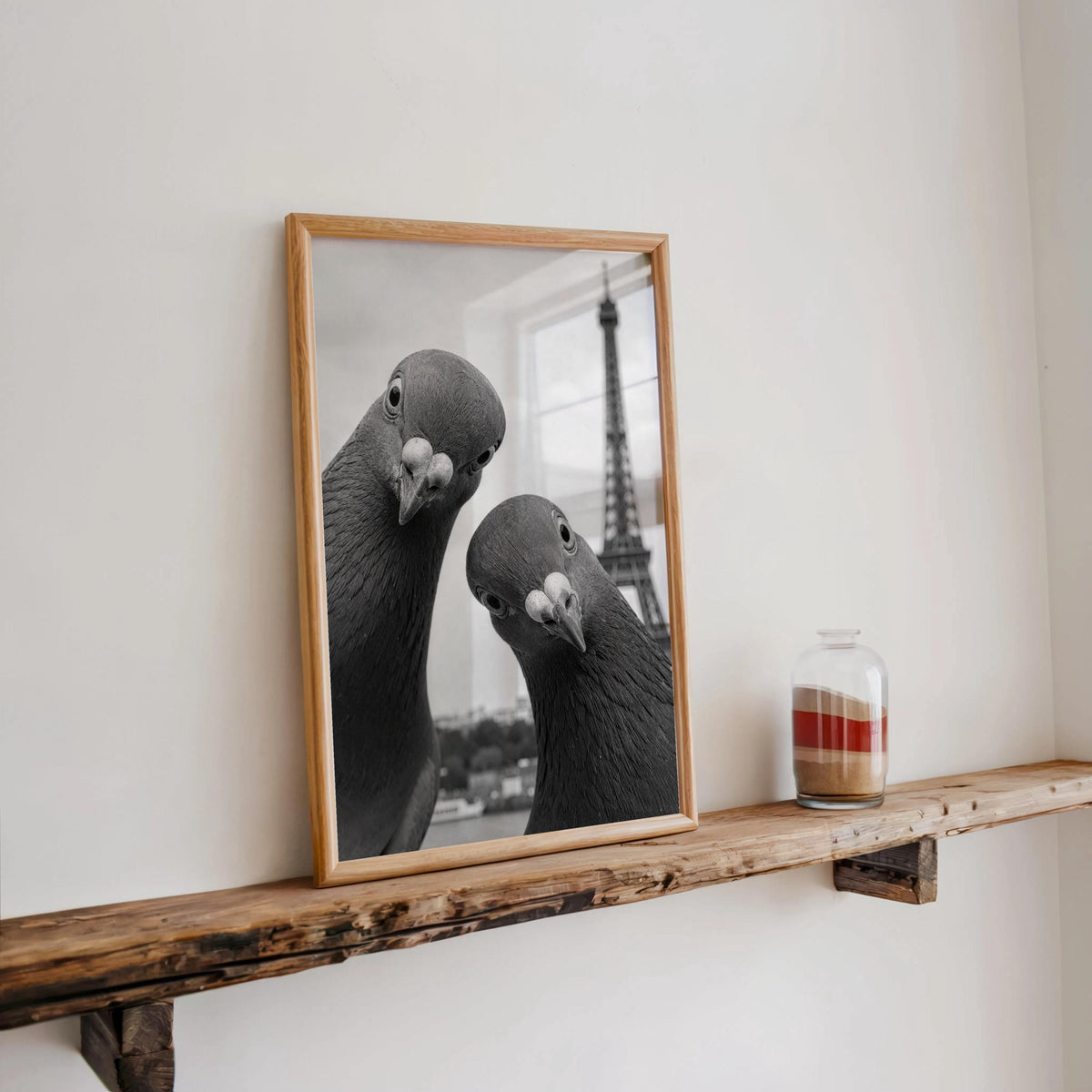 Rustic floating ledge displaying framed pigeon print with a candle and jar, Paris travel wall decor meets quirky animal wall art