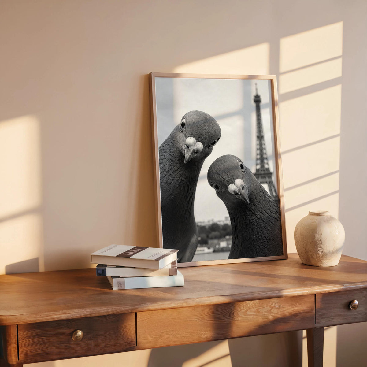 Sunlit wooden console with propped framed black and white pigeon print, vintage Paris travel vibe, funny pigeon wall art