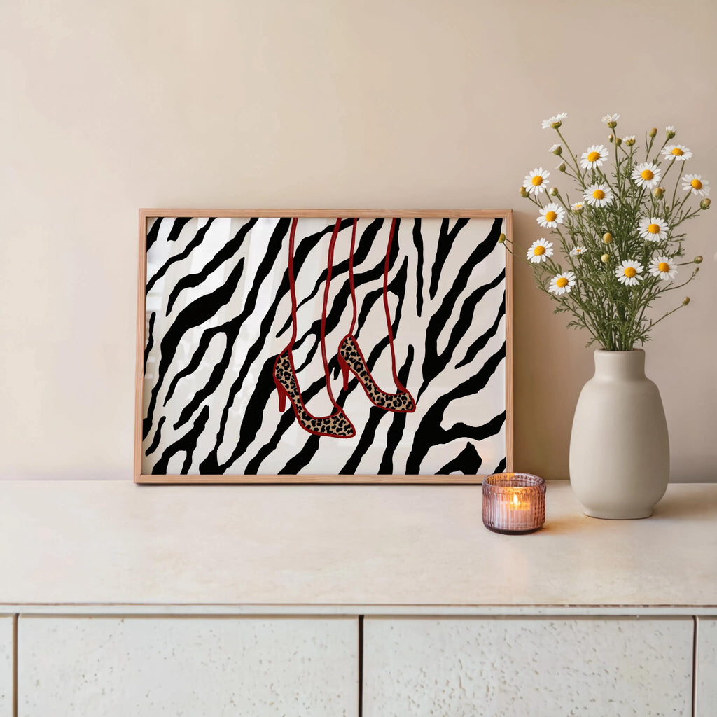 Console table styling with black and white zebra print, hanging leopard heels with red straps, trendy boutique wall decor, leopard heels wall art