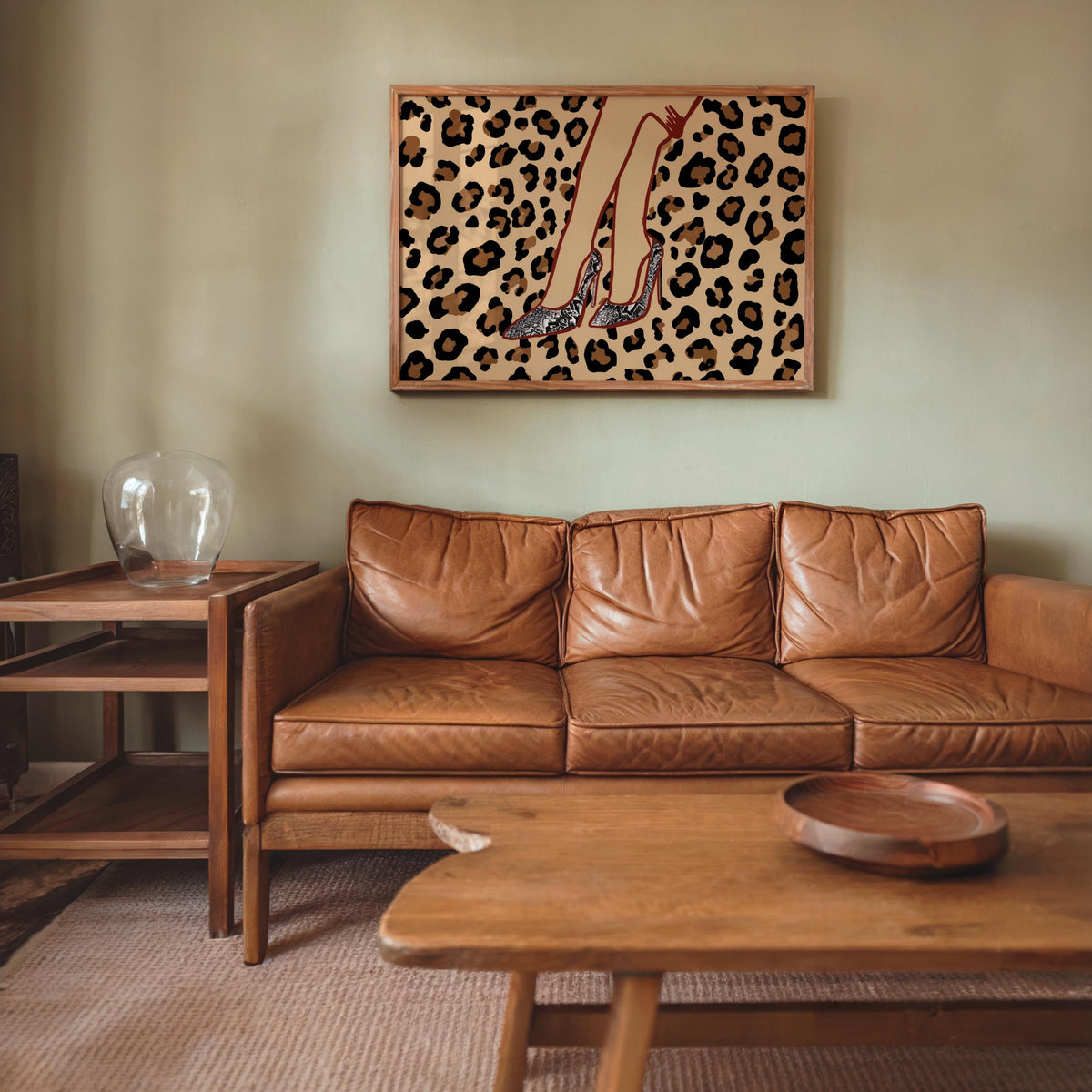 Framed leopard print high heel wall art above leather sofa, boutique wall art print vibe in warm tones